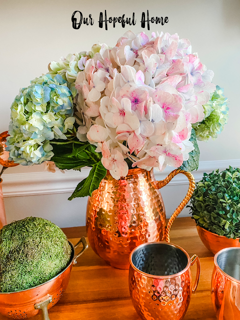 hammered copper pitcher filled with fresh hydrangeas