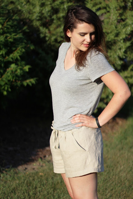 Brunette girl modeling tan linen summer shorts with gray tshirt