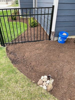 Downspout extender under mulch with rocks