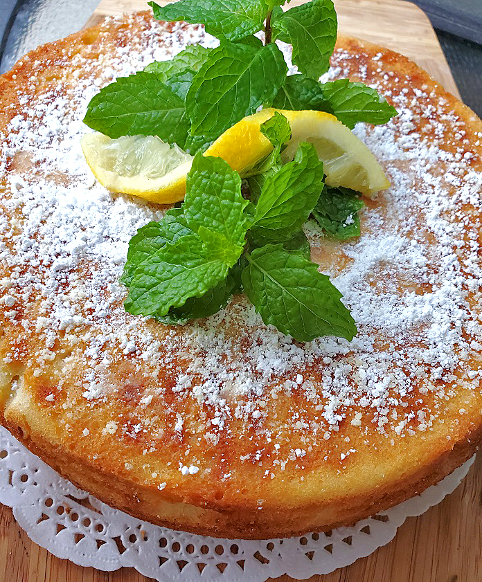 this is a homemade lemon cake with powdered sugar and mint on top