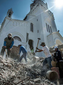 Voluntários nos escombros da torre da Basílica em Montecristi