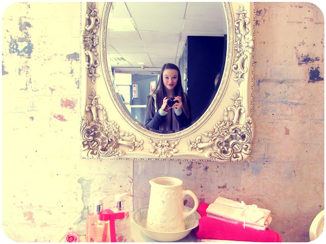 girl takes photo of herself in round white engraved mirror