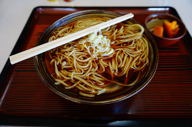 Bowl of hot soba noodles with a side dish of soft pumpkin in Togakushi, Japan