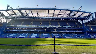 Wide angle view of the seating on the long side of the soccer pitch at Stamford Bridge. The seats spell out Chelsea in white.