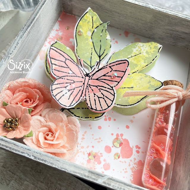 Mixed media vignette in coral and sage created with Sizzix 49 & Market layered stamps, Tim Holtz vignette box, Distress Oxides, and Prima Marketing flowers.