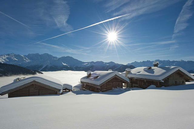 Picture of three wooden houses buried in snow