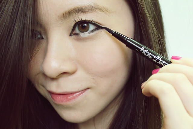 Girl applying eyeliner