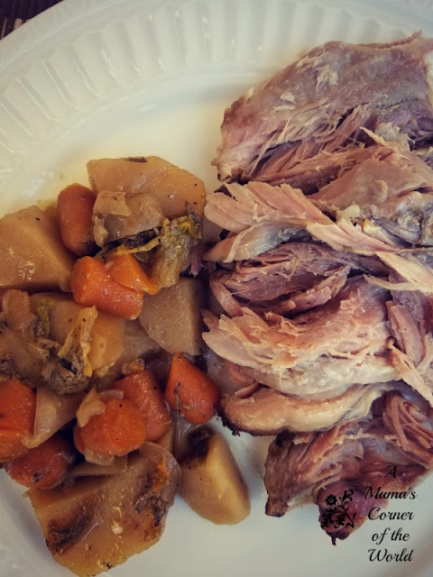 Shredded pork roast with carrots, potatoes, onions and celery on a white plate.