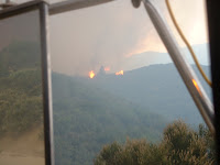 View out drivers window spot fire across ridge