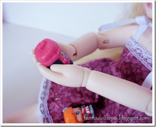 A ball jointed doll holding a My Mini Mixie Q's figure.