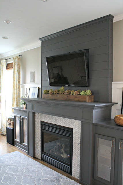 gray fireplace with herringbone marble tile