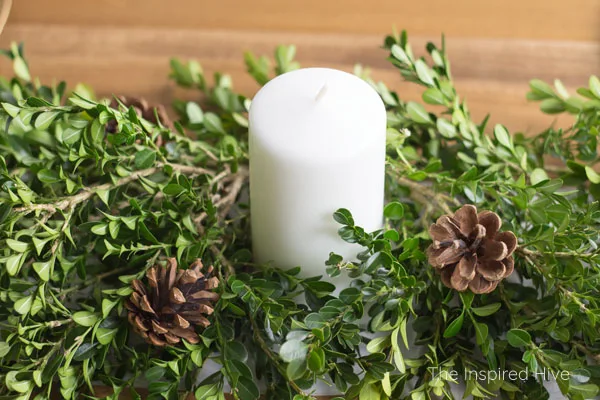 How to decorate a table for Christmas on a budget! Beautiful farmhouse winter tablescape using a boxwood runner as a DIY centerpiece.