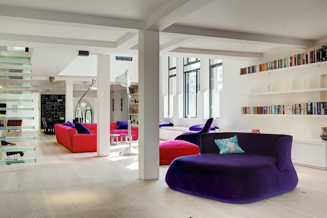 Picture of open living room with pink couch and purple chair