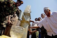Lt. Col. Juma, commander of 9th Kenyan Rifles Battalion, helps pump water from newly dedicated well in Delolo, Kenya. American Soldiers and Sailors teamed with local Kenyans to install the well.