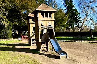 A wooden climbing frame with slide in Oaklands Park Chelmsford