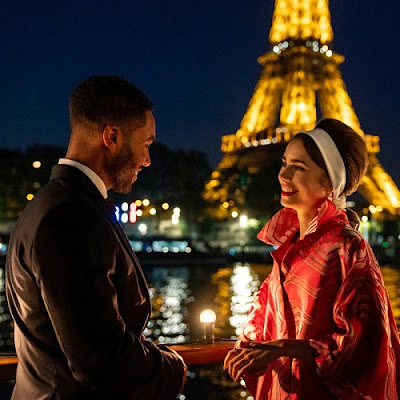 Una pareja se mira y sonríe delante de la torre Eiffel
