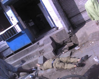 policeman lies drunk on road in Delhi, India