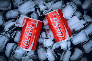 2 cans of coca cola in an ice bucket