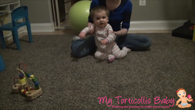 Baby with torticollis getting ready to a physical therapy exercise with her mother