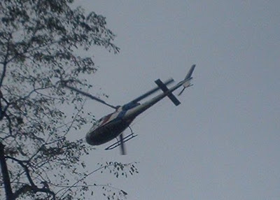 helicopter flying above marchers