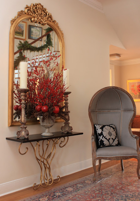 Porta Romano table with a domed wing chair and an antique mirror.