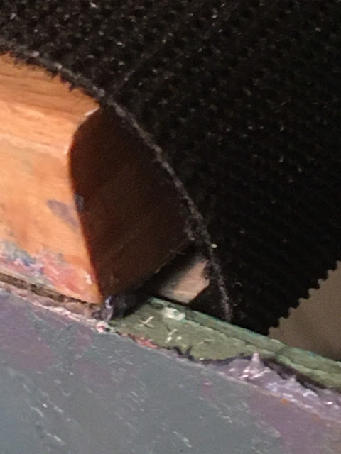 Close up of corner of top support bracket, showing backstop behind panel with velcro wrapped around to secure it to top surface