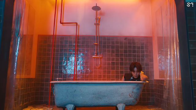 Yuta z NCT w wannie. Na ścianie widać także prysznic, po bokach zasłony prysznicowe