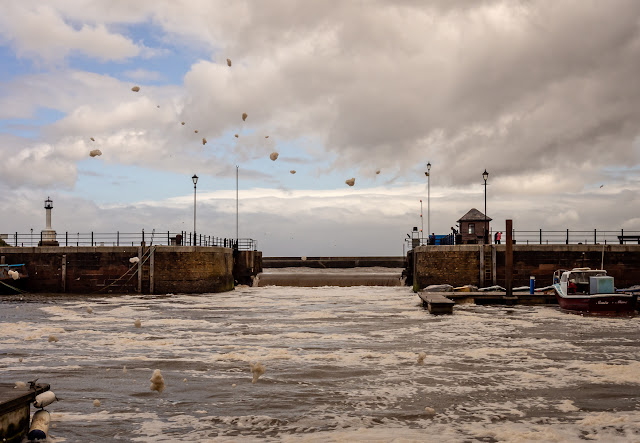 Photo of water pouring over the marina gate when it was left closed during Storm Hector in June