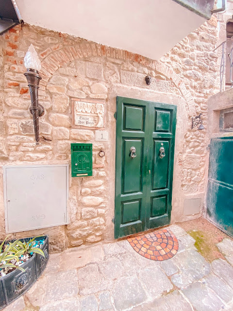 ingresso portone verde antico di una casa torre antica