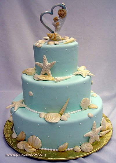 Light blue wedding cake with three round tiers and decorated with lovely sea