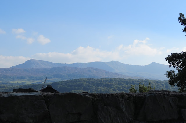 Below almost clear blue skies, the entire north face of the mountain across the horizon.