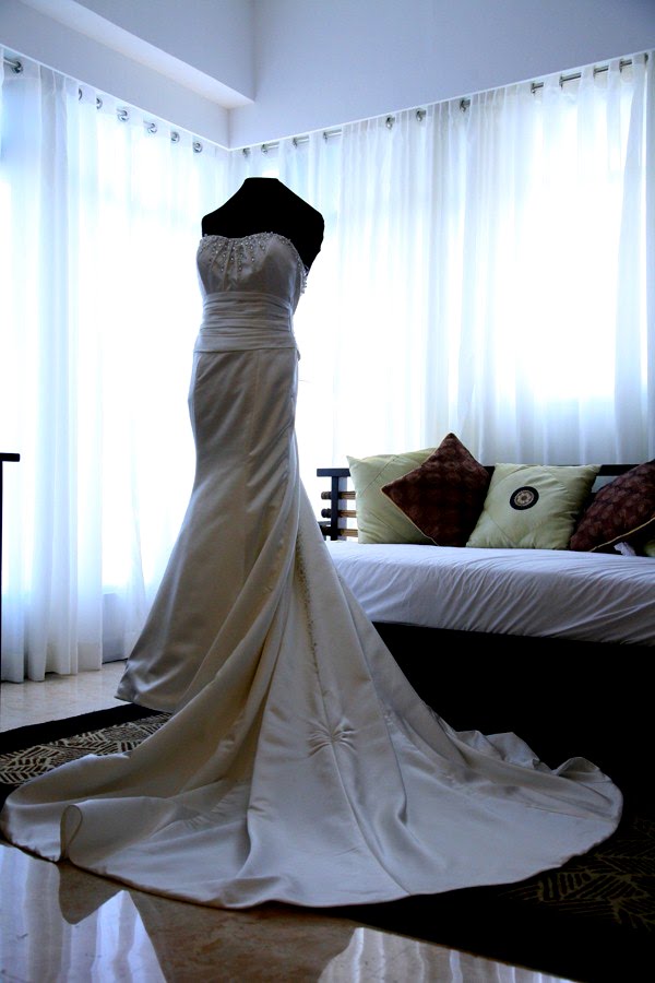 It is an ivory white silk satin wedding gown with elegant pearl beadworks