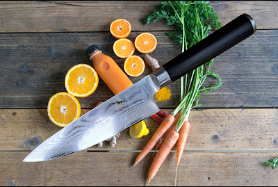 Shun kitchen knife surrounded by fresh market produce.