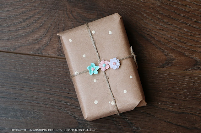 Completed wrapped gift box with twine, and floral embellishments