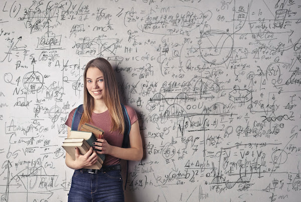 girl with school books in front of white board