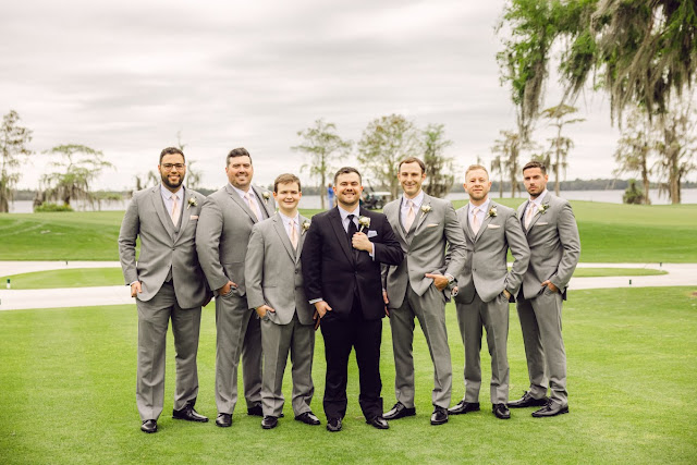 groom in black tux and groomsmen in grey suits