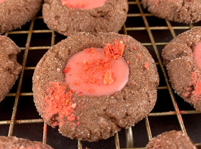 Chocolate thumbprint cookies with a strawberry and white chocolate ganache filling, sprinkled with crushed freeze-dried strawberries