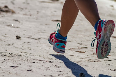 A woman's feet running along the beach