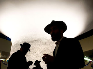 Orthodox Jews are silhouetted against the rotunda in City Hall during the Chanukah event called 'Occupy City Hall' in Toronto on Sunday, December 9, 2012.Darren Calabrese/National Post