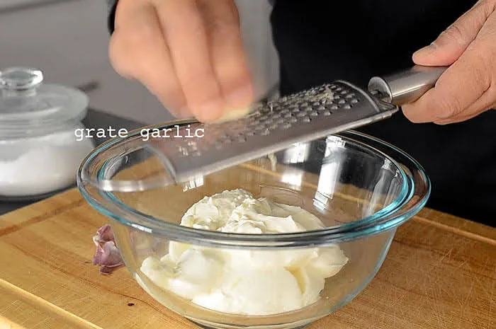 grate garlic into greek yoghurt for cilbir