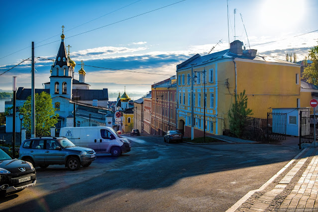 Улица в городе, припаркованные машины и церковь