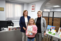 Zdjęcie przedstawia pracownice biblioteki wręczając dyplom i nagrodę laureatowi Gminnego konkursu plastycznego pt. "Mój ulubiony bohater bajkowy”.