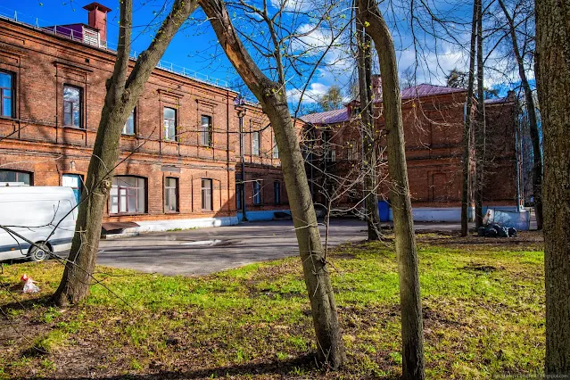 Старое кирпичное здание за деревьями
