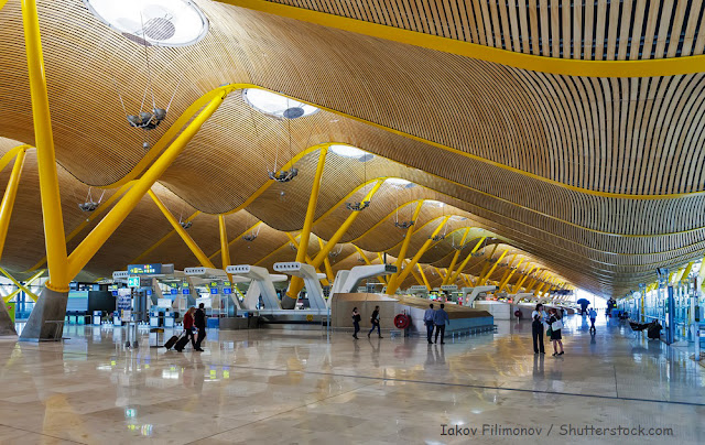 foto de corredor e saguão do aeroporto com seu teto ondulado tudo em amarelo    