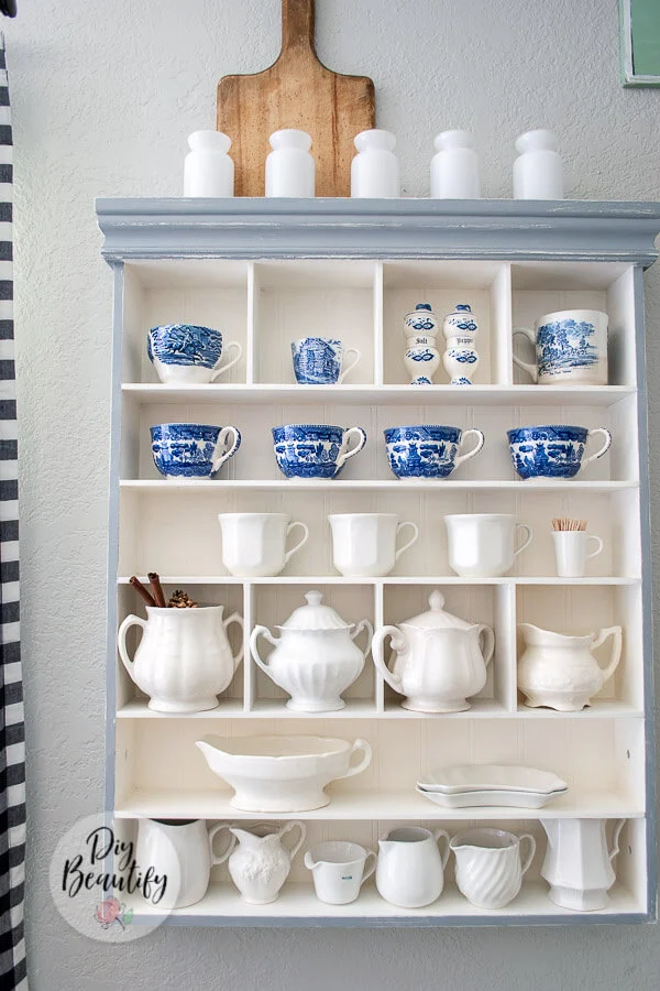 wall cubby filled with vintage ironstone creamers and pitchers