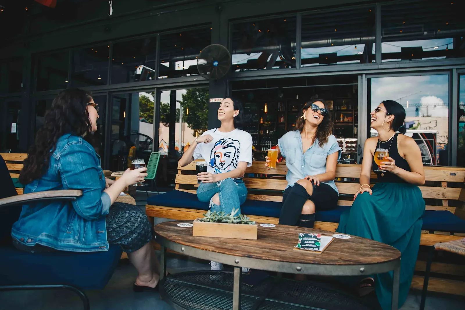 A group of girls sitting around in benches and chilling and laughing. Lifenatphil communication girls tips life