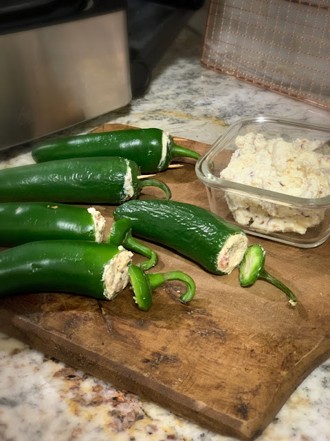 Whole Jalapeno Poppers, a spicy, cheesy, grilled appetizer.  The recipe is straightforward with few ingredients, jalapenos, cream cheese, white cheddar cheese, garlic powder, and of course bacon.