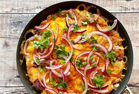 Spanish potato and chorizo omelette in a frying pan.