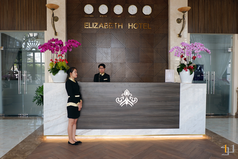 Quầy lễ tân khách sạn làm từ gỗ óc chó và đá marble