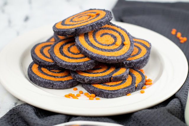 pile of cookies on a white plate with gray background.